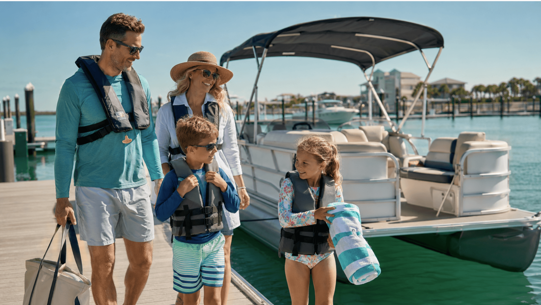 Family wearing life jackets beside a pontoon boat before a Destin boating trip