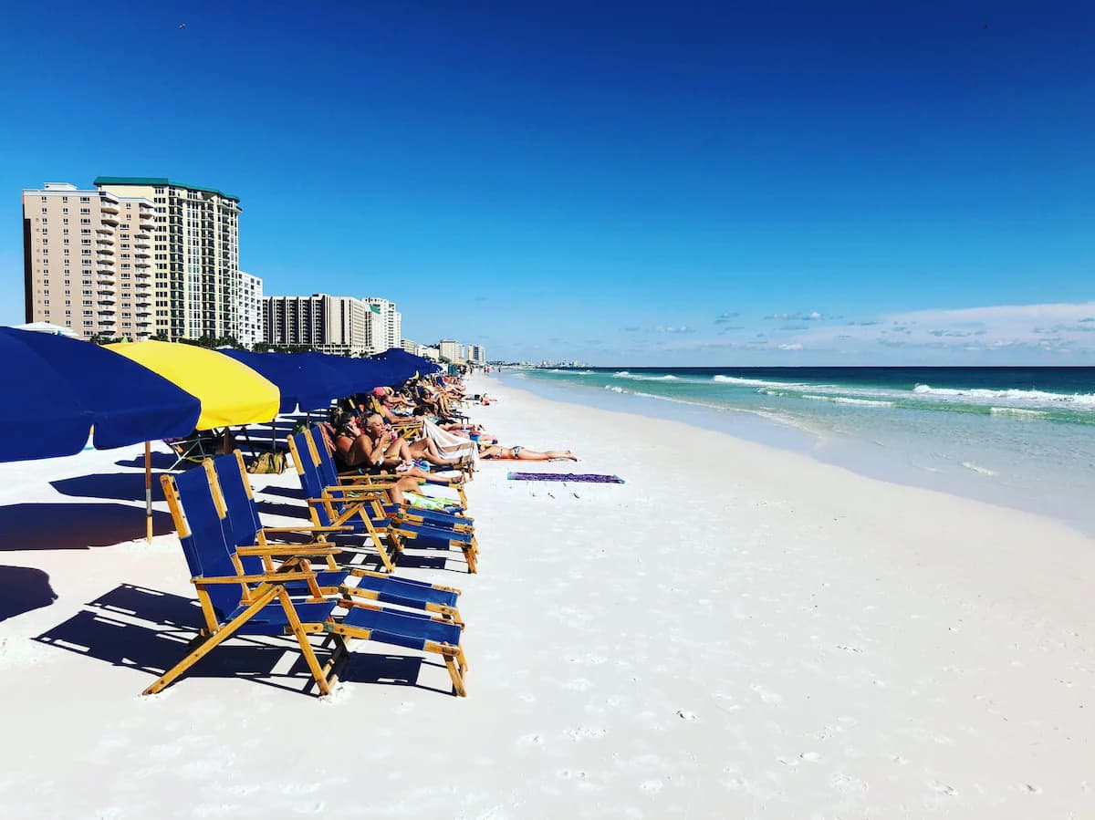 Organized beach chairs and umbrellas on the sand at Pelican Beach Resort